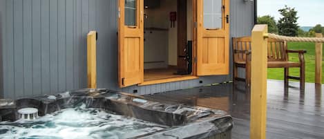 Un área de spa con un jacuzzi y terraza de madera.
