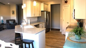 A modern kitchen with a central island, stainless steel appliances, and pendant lighting.