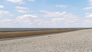 A beach with pebbles and a clear sky. - 2 bedroom accommodation in Towyn (Towyn)