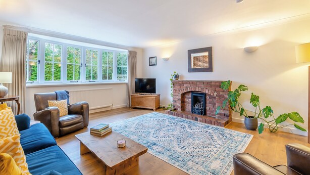 A living room with a fireplace, a sofa, a coffee table, and a television.