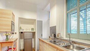 A modern kitchen with wooden cabinets, a stainless steel sink, and a built-in oven.