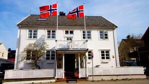 Un bâtiment blanc à deux étages, doté d’un balcon et d’une véranda.