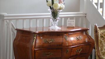 A wooden dresser with drawers and a vase of flowers on top.