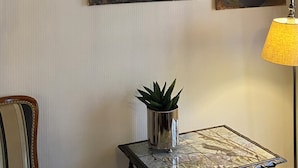 Une pièce avec six tableaux accrochés au mur, une table avec une lampe et une plante en pot.
