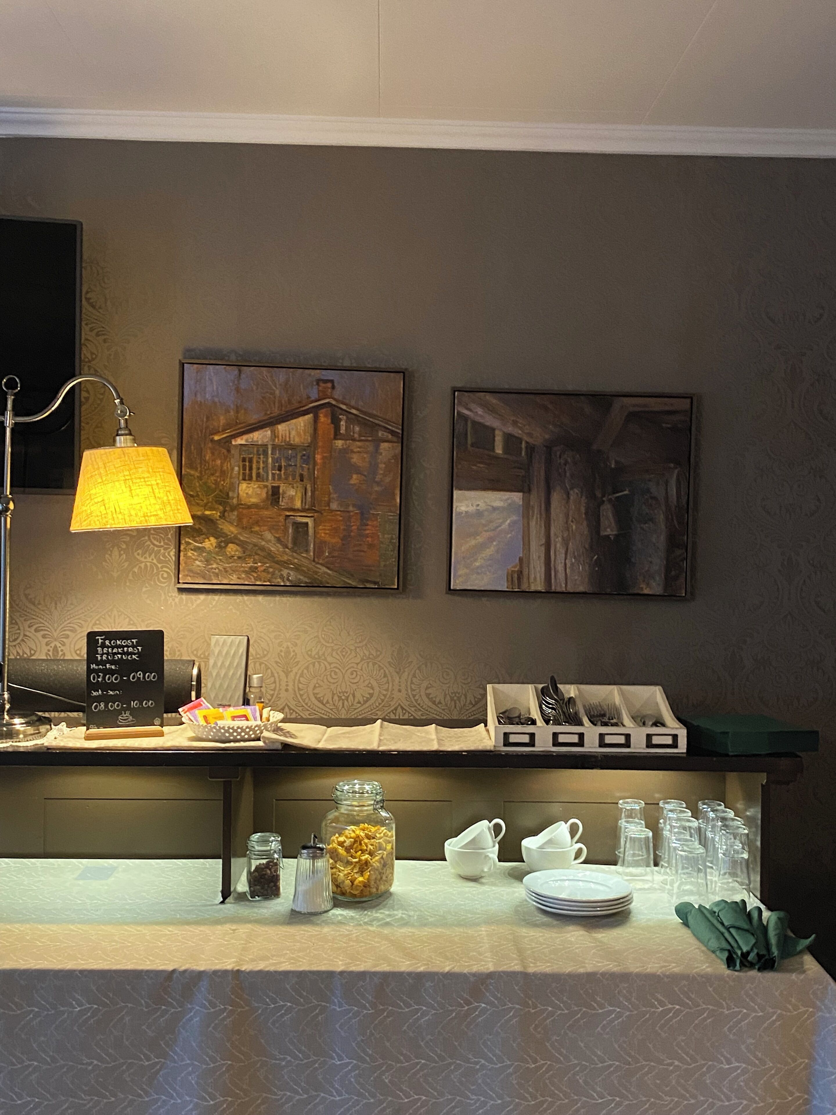 A breakfast bar with a lamp, a chalkboard menu, and various breakfast items.