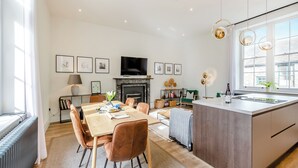 Una cocina moderna con comedor, chimenea y televisor montado en la pared.