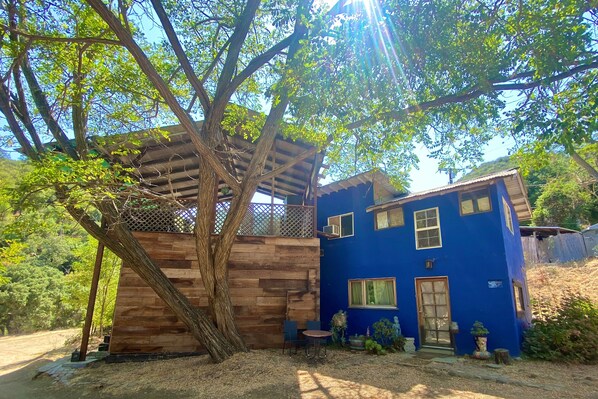A two-story house with a wooden deck and a blue exterior.