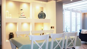 A dining area with a table set for four, white chairs, and a green tablecloth. - 4 bedroom accommodation in Shanklin (Shanklin)