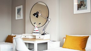 A hotel room with a bed, a desk with a chair, a desk lamp, a mirror, and a framed picture on the wall. - 4 bedroom accommodation in Shanklin (Shanklin)