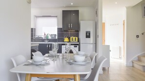 A modern kitchen with dark cabinets, a stainless steel refrigerator, and a yellow kettle. - Coastal Soul - UK43464 (Lake, near Sandown)