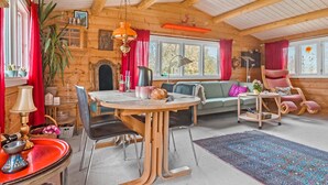 A cozy log cabin interior with a dining area, a sofa, and a chair. - 3 bedroom stunning home in Slagelse (Slagelse)