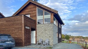 A modern two-story house with a wooden exterior and a stone facade. - Amazing home in Oppdal (Oppdal)