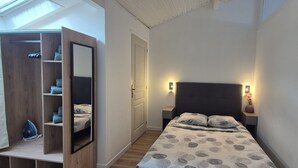 Een slaapkamer met een bed, een kledingkast en een spiegel.