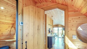 A wooden interior with a door leading to a kitchen area. - This luxury lodge with a private hot tub is perfect for exploring Mid Wales. (St Harmon, near Rhayader)