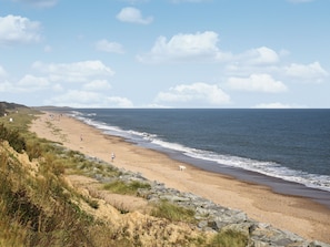 A coastal beach with rocky terrain, a sandy shore, and the ocean.