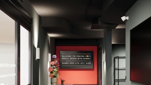 A reception area with a modern design, featuring a reception desk, a welcome sign, and a potted plant.