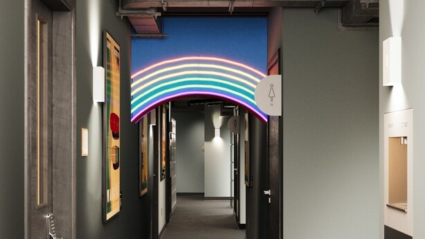A hallway with a trash bin, a water dispenser, and a ceiling with a blue and white striped design.