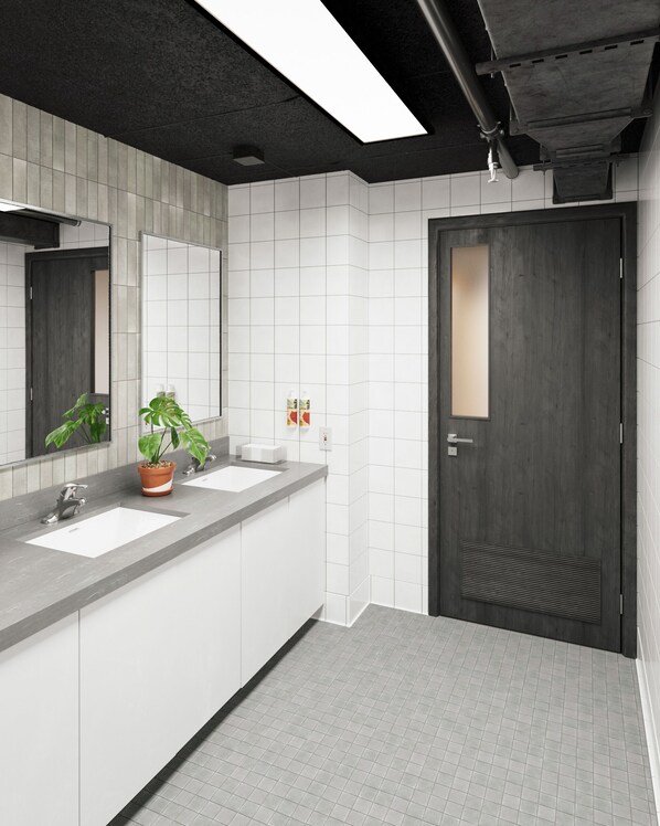A modern bathroom with two sinks, a large mirror, and a potted plant. - Podtel (Honolulu)