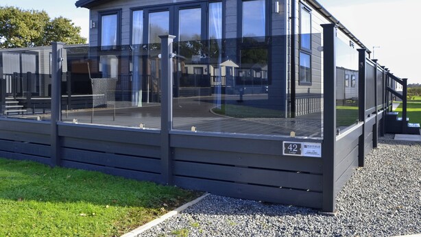 Un edificio moderno de una sola planta con ventanas amplias y techo plano, identificado como '42 Lodge' con un número de contacto.