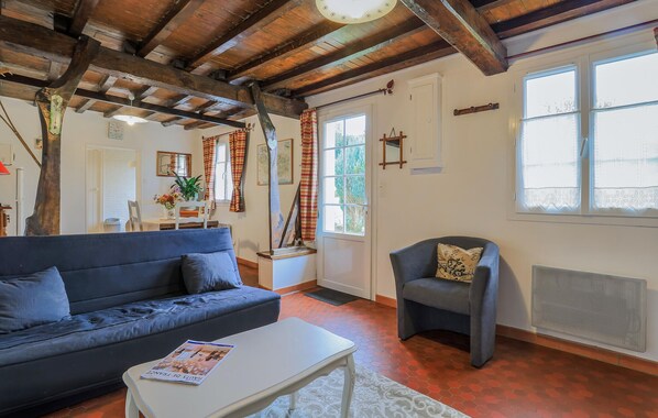 Ein gemütliches Wohnzimmer mit einem dunkelblauen Sofa, einem weißen Couchtisch und einem grauen Sessel.