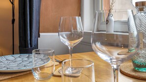 A wooden table with various glassware and a decorative plate. - Top Floor Spacious King Size Apartment | City Views | Excellent Transport Links (Edinburgh)