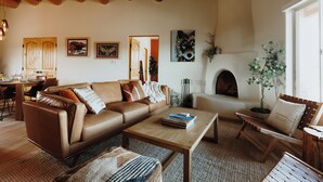 Una sala de estar acogedora con un sofá de cuero marrón, una mesa de centro de madera y una chimenea.
