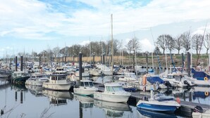 A marina with numerous boats docked, calm water, and trees in the background. - Amazing home in Gueschart with house sea view (Gueschart)