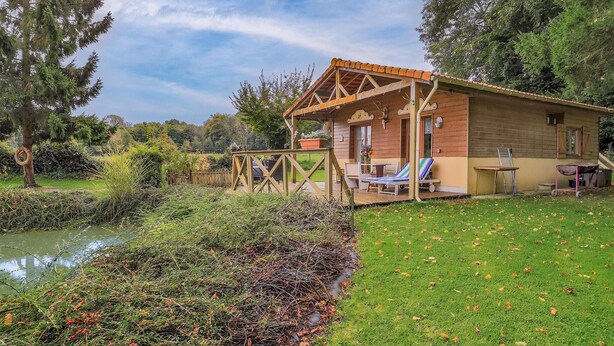 A wooden cabin with a deck, a small garden, and a pond. - Amazing home in Gueschart with house sea view (Gueschart)