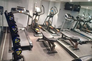 A gym with various exercise equipment including treadmills, elliptical machines, and stationary bikes.