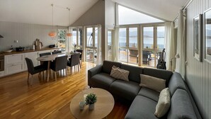 Ein modernes Wohnzimmer mit einer Couch, einem Couchtisch und einem Essbereich mit Tisch und Stühlen.