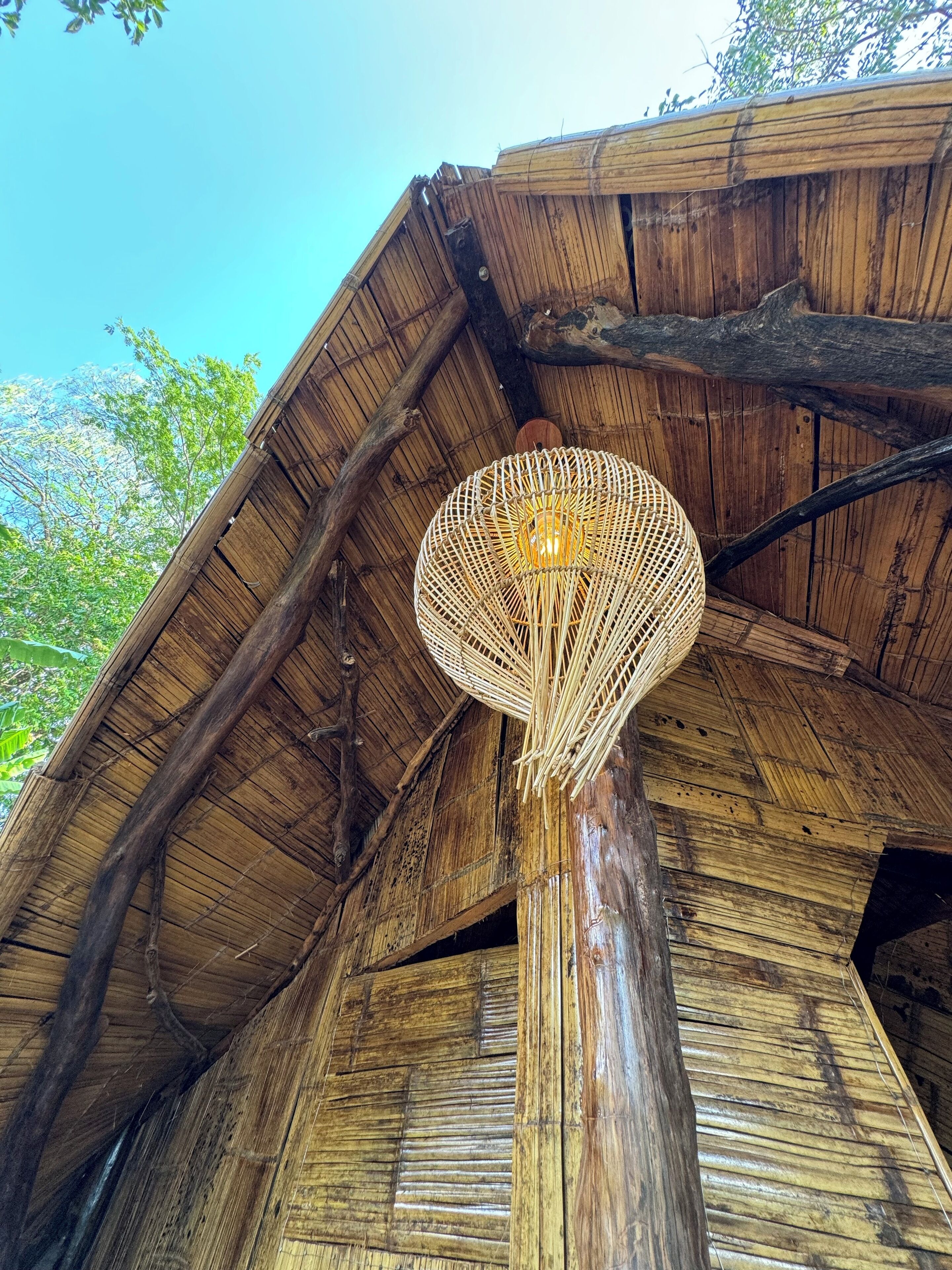 A bamboo structure with a woven light fixture.