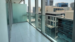 A balcony with a view of modern buildings and a clear sky. - Damac Majestine VIP (Dubai)