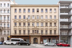 Un immeuble à étages doté d’un style architectural classique, avec une entrée centrale surmontée d’un arc décoratif.