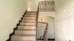 A staircase with a handrail and a metal railing on the upper landing.