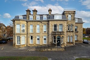 A historic stone building with multiple windows and a central entrance.