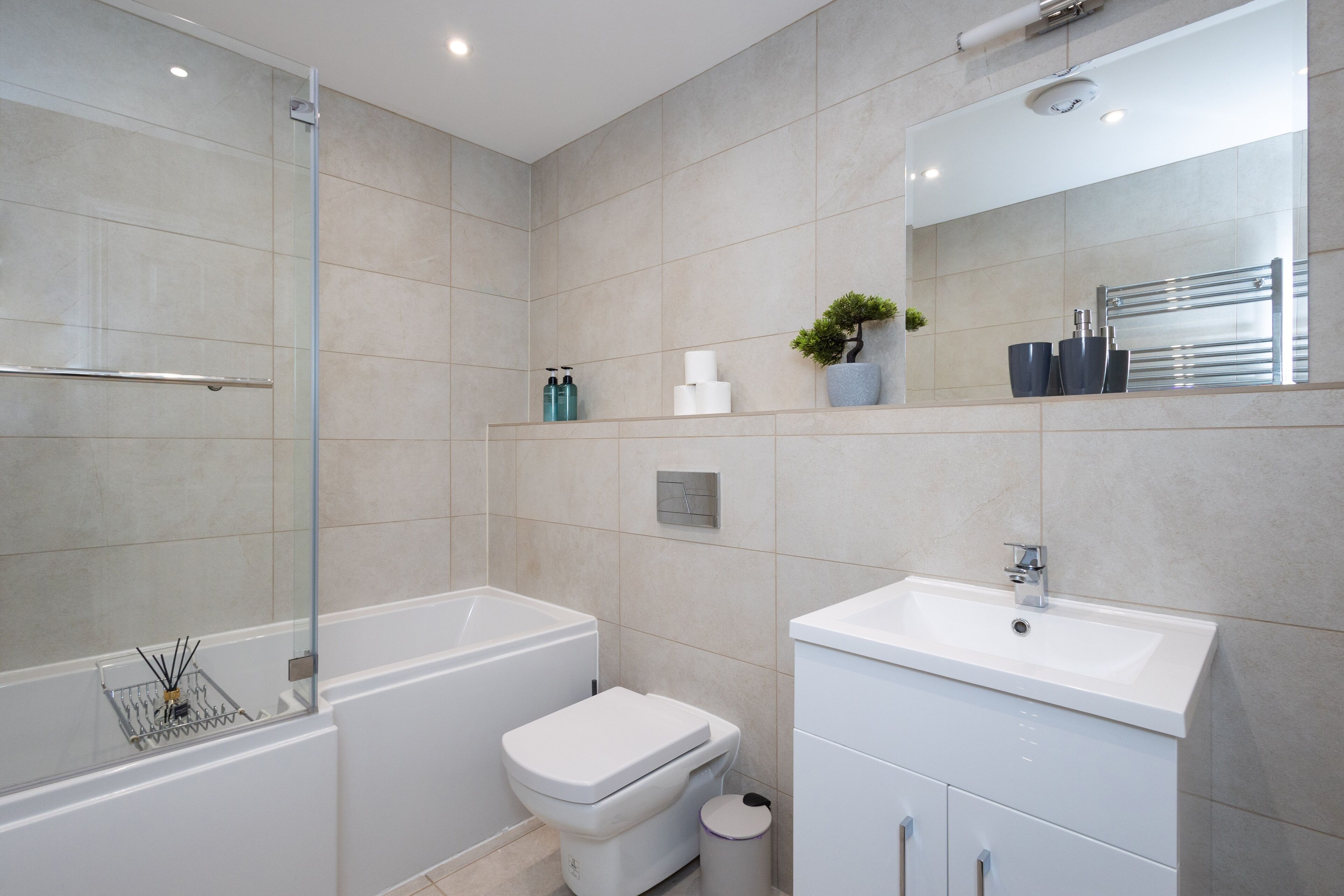 A modern bathroom with a bathtub, toilet, and sink.