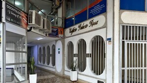 Entrada de un edificio con suelo de baldosas, plantas en macetas y un letrero que dice 'Odontologia Viviancy'.