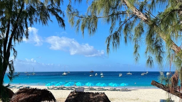 A beach with clear blue water, boats, and umbrellas. - The Lotus Room, Carlisle Bay, Eden On The Sea  (Bridgetown)