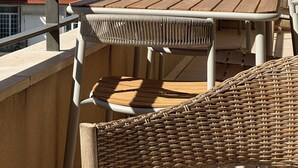 A terrace with wicker furniture, a table, and a view of a cityscape and mountains. -  Carre D’Or - Discover a unique address in the heart of Promenade des Anglais.  (Nice)
