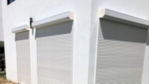 A building with two closed roller shutters.