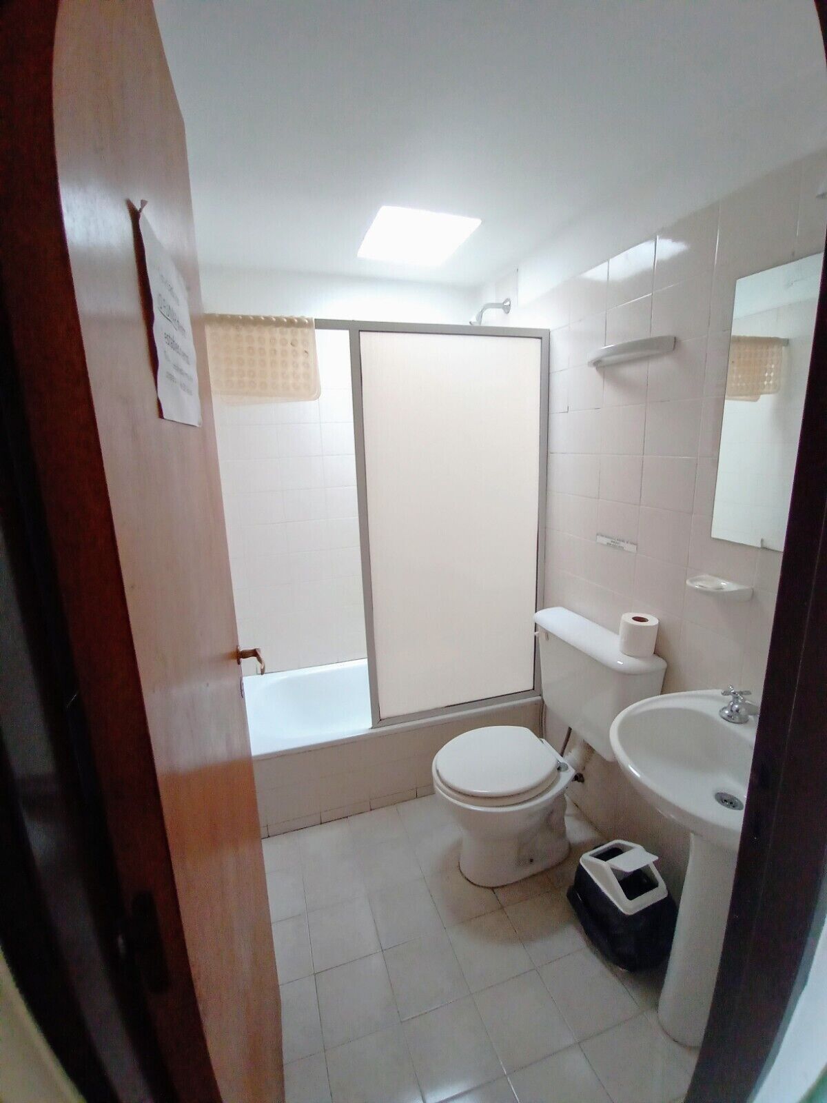 Un baño pequeño y limpio con inodoro, lavabo y ducha.