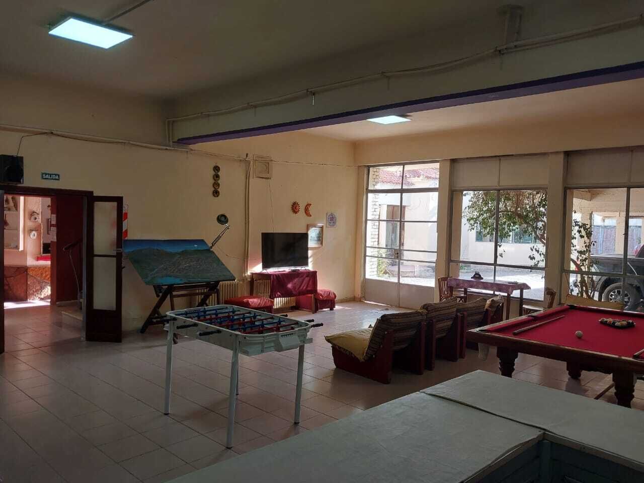 Una habitació amb taula de futbolí, taula de bitlles i un quadre a la paret.