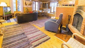 Un salon confortable avec une cheminée, un canapé et un téléviseur.