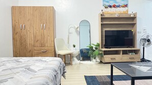 Makuuhuoneessa on sänky, puinen vaatekaappi, televisio, peili, tuoli, pieni pöytä ja tuuletin.