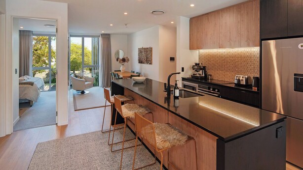 A modern kitchen with a central island, stainless steel appliances, and a view to the outdoors. - Malthouse Lane City Apartment 4 with Stunning Hill Views in Nelson CBD (Nelson)