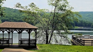 A gazebo with a view of a lake and forested hills.