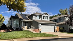 A two-story house with a garage, a front porch, and a well-maintained lawn. - Charming Broomfield Retreat: Modern Comforts & Prime Location
 (Broomfield)