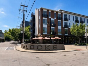A modern building with a sign that reads 'BLOCKS' and a street with a bike lane. - Midtown 1BR Hideaway: Steps to Ice Blocks (Sacramento)