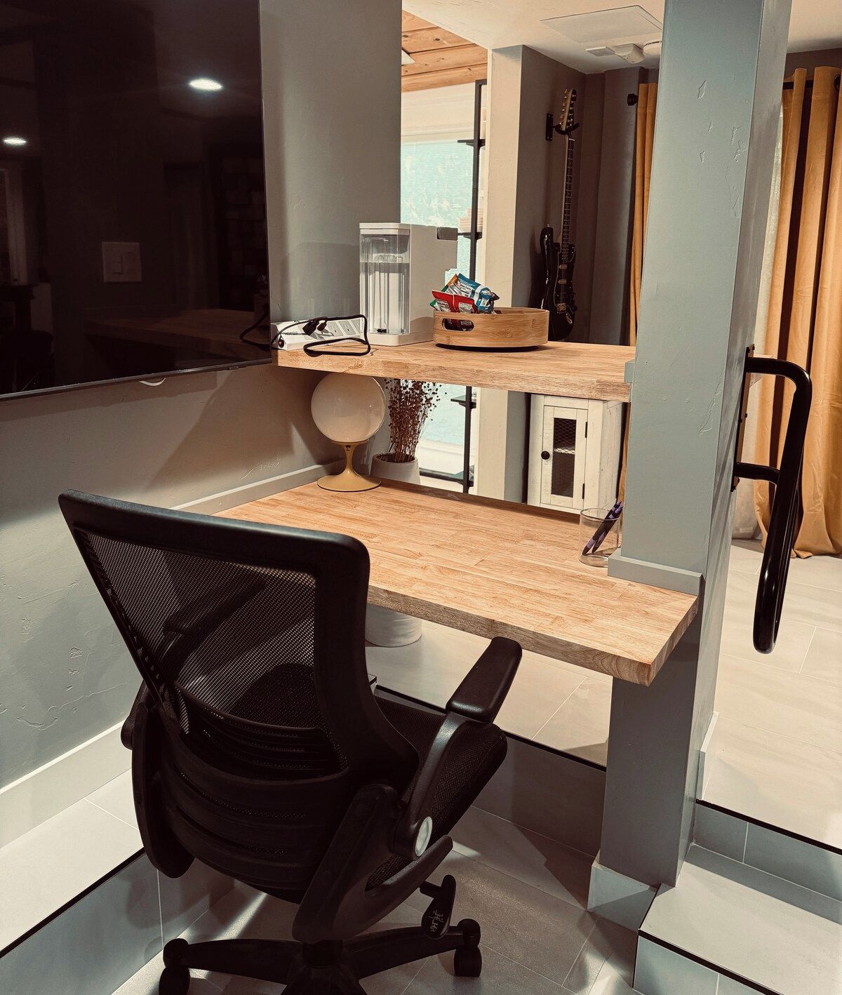 A modern office space with a desk, chair, and a window overlooking a cityscape.