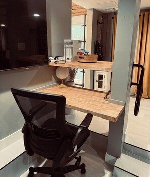 A modern office space with a desk, chair, and a window overlooking a cityscape. - Midtown 1BR Hideaway: Steps to Ice Blocks (Sacramento)